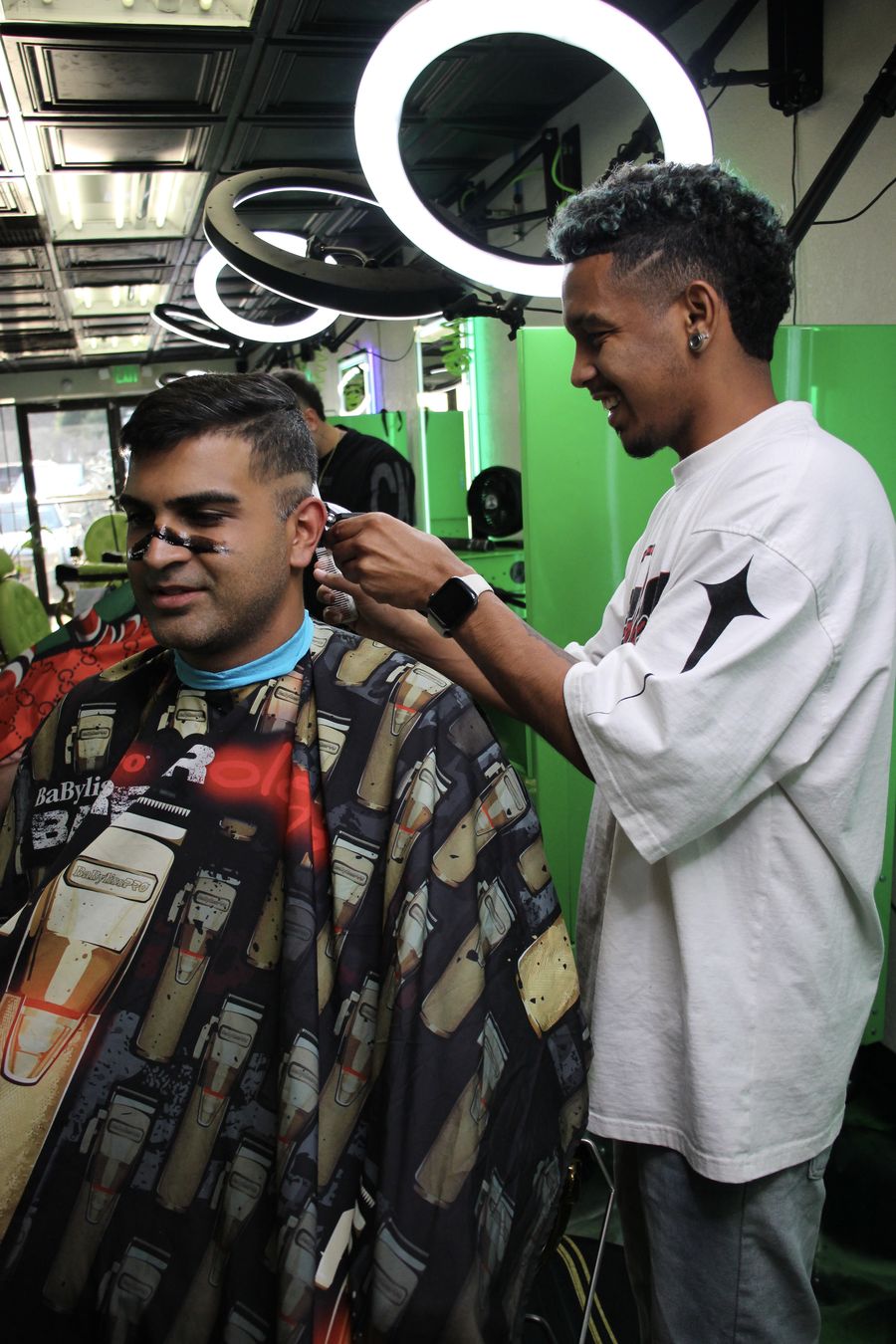 Barber finishing client's cut with a smile